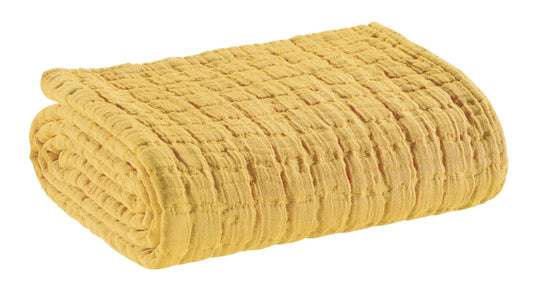 coperta swami curry, colore curry, taglia 180 x 260. vista frontale della coperta piegata su sfondo bianco