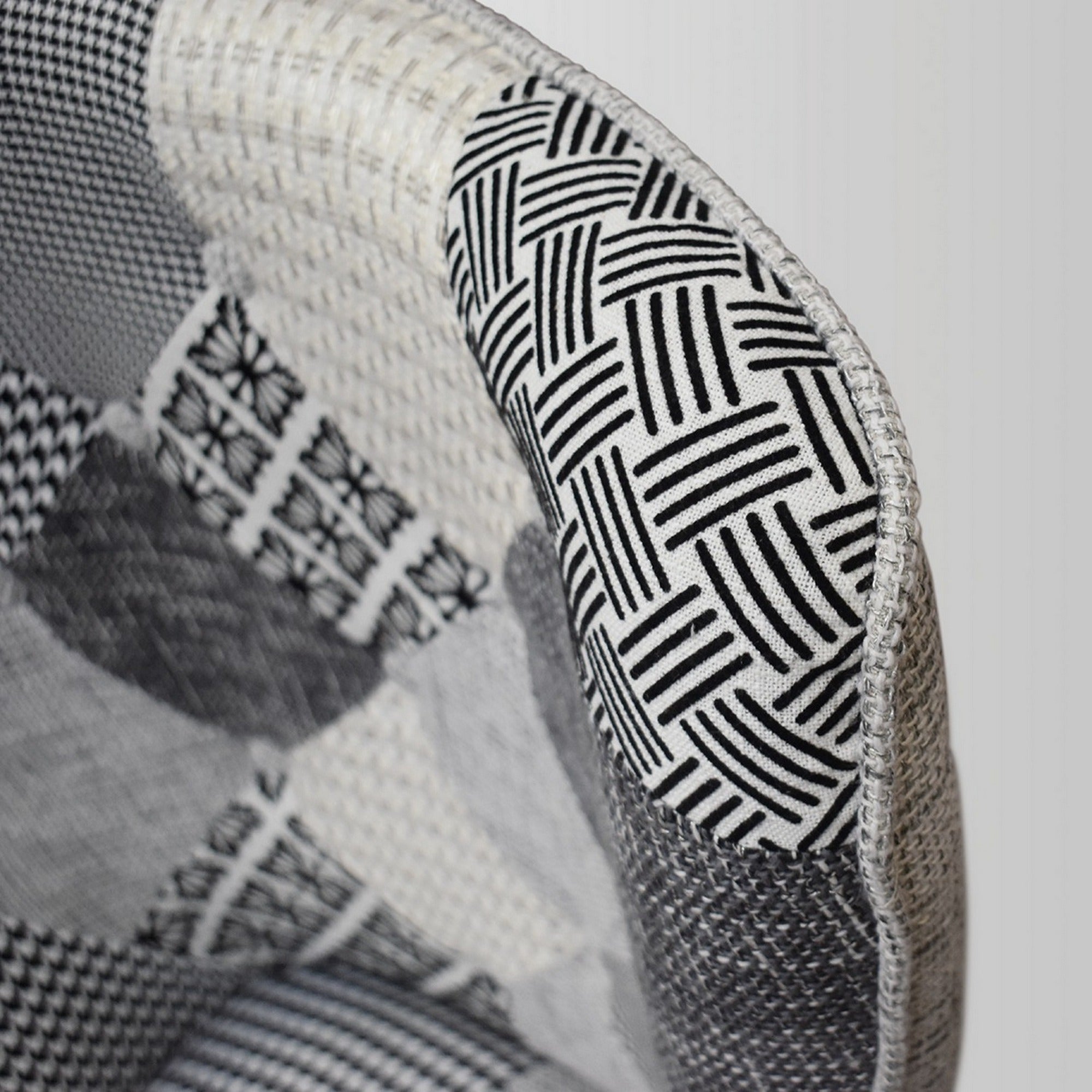 poltrona havana in tessuto patchwork grigio e gambe in legno, dettaglio del rivestimento in tessuto o velluto