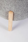pouf dayla in tessuto grigio chiaro effetto bouclé e gambe in legno rubber wood, dettaglio delle cuciture e materiali di...