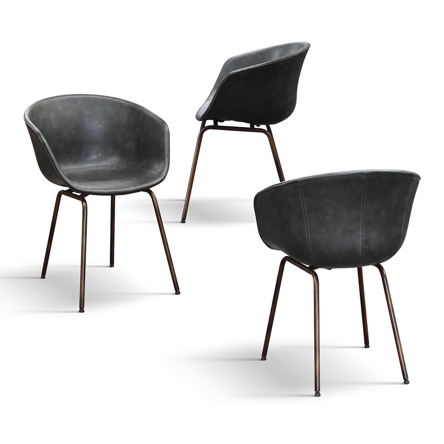 set di 4 sedie copenaghen rivestite in pelle antracite e gambe in metallo nero, vista ambientata attorno a un tavolo da...