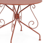 tavolo etienne in acciaio rosso ø90 cm, ambientazione in giardino con sedie coordinate