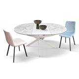 tavolo filicudi rotondo ø120 allungabile, in ceramica effetto marmo e base bianca metallo, vista ambientata con sedie...