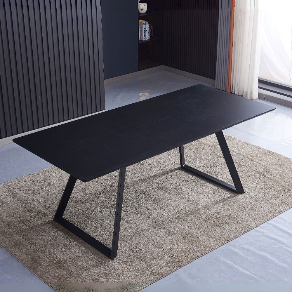 tavolo allungabile shelton con piano impiallacciato legno massiccio tinto nero e gambe in metallo nero, dettaglio della superficie allungata e gambe robuste