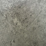 tavolo tondo logan con piano cemento e gambe in metallo nero φ120*76.5 cm., forma accogliente che favorisce la socialità