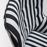 poltrona havana in tessuto a righe bianco e nero e gambe in legno, con poggiapiedi, dettaglio del rivestimento in tessuto o...